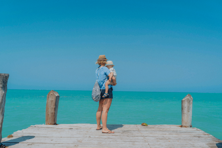 Lycklig familj på en strand i Zanzibar med turkost vatten