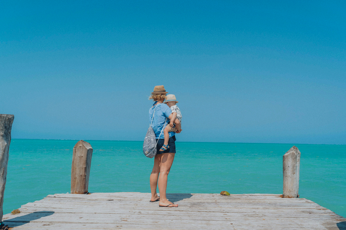 Lycklig familj på en strand i Zanzibar med turkost vatten