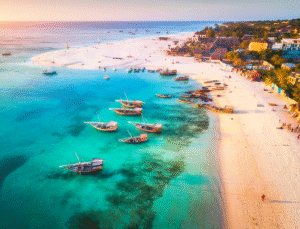 Utsikt över den långa, vita sandstranden i Jambiani Zanzibar med vajande palmer och avkopplande atmosfär