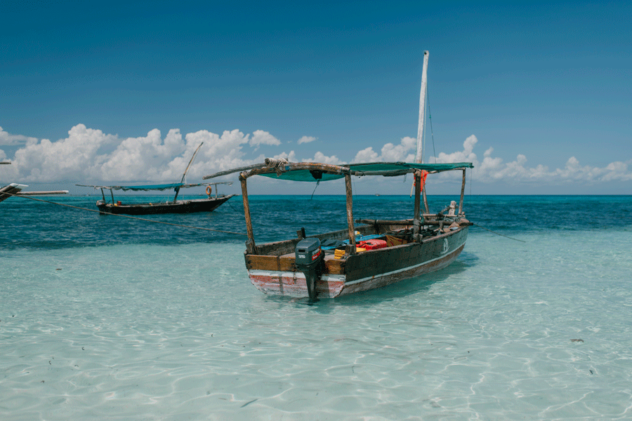 Paje strand på Zanzibar med kitesurfare och vit sand vid lågvatten