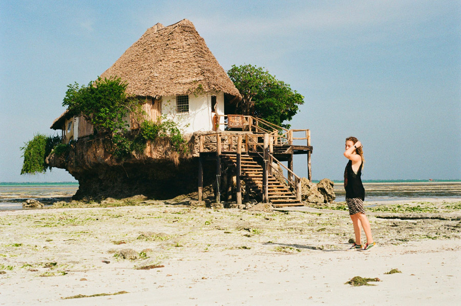 Solnedgång med dhow-båt på lugnt hav på Zanzibar i december